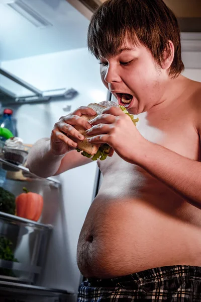 Głodny trzymając kanapkę w jego ręce i stojący obok — Zdjęcie stockowe