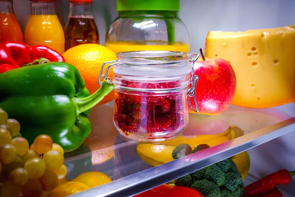 在一个架子上的玻璃罐子里的新鲜树莓打开冰箱 — 图库照片