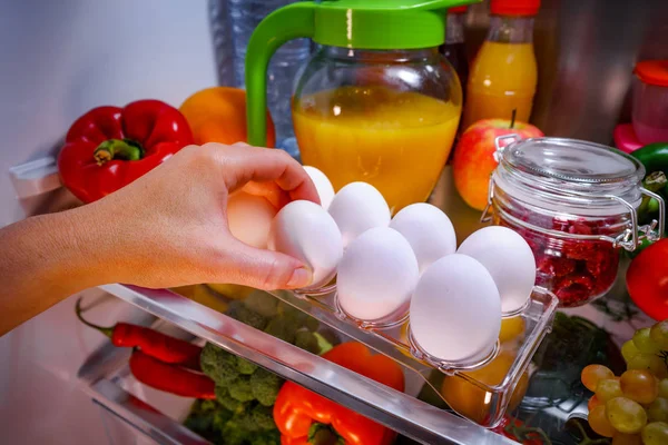 Ovos de frango em uma prateleira refrigerador aberto — Fotografia de Stock