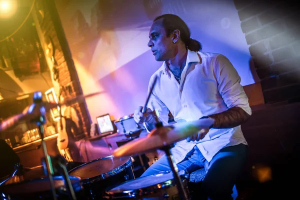 Drummer playing on drum set on stage. Warning - Focus on the drum, authentic shooting with high iso in challenging lighting conditions. A little bit grain and blurred motion effects. — Stock Photo, Image