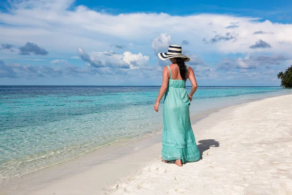 Ragazza che cammina lungo una spiaggia tropicale alle Maldive . — Foto Stock