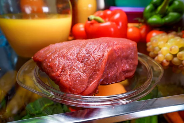 Carne fresca cruda en un refrigerador abierto estante — Foto de Stock