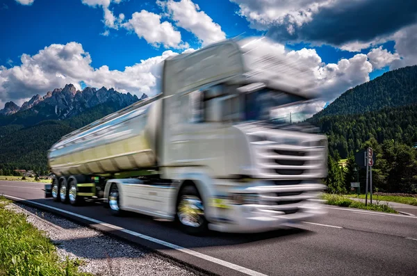 Brandstof vrachtwagen rent onderaan de weg op de achtergrond de Alpen. T — Stockfoto