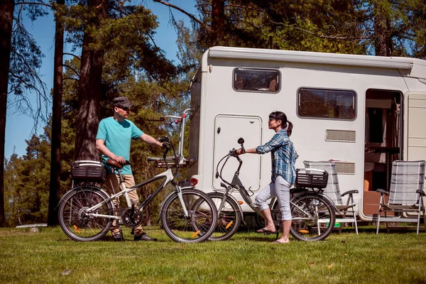 Frau mit Mann auf Elektrofahrrad rastet auf dem Campingplatz aus. — Stockfoto