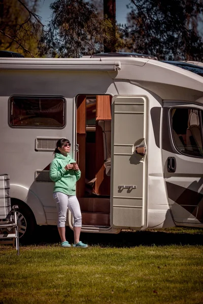 Mujer está de pie con una taza de café cerca de la caravana RV . — Foto de Stock