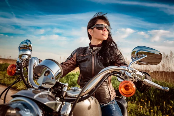 Байкерша сидит на мотоцикле — стоковое фото