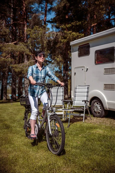 Mulher em bicicleta elétrica descansando no parque de campismo VR Caravan car Va — Fotografia de Stock