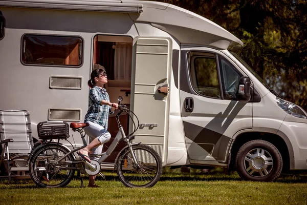 Mulher em bicicleta elétrica descansando no parque de campismo VR Caravan car Va — Fotografia de Stock