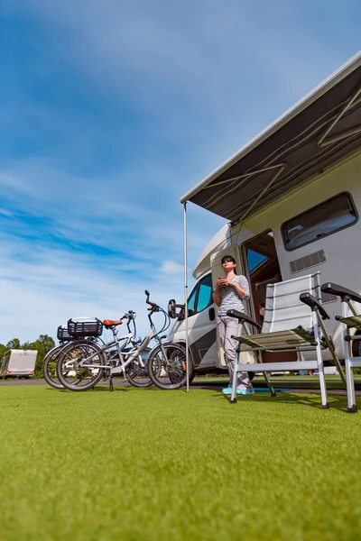 Woman is standing with a mug of coffee near the camper RV. — Stock Photo, Image