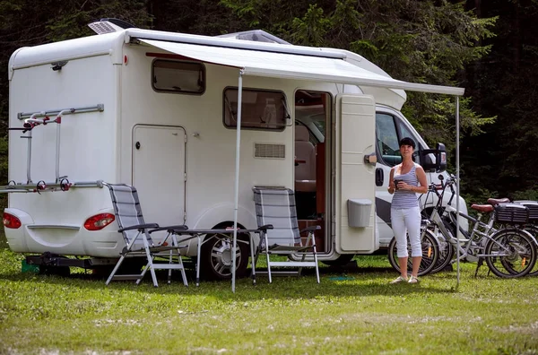Femme est debout avec une tasse de café près du camping-car RV . — Photo
