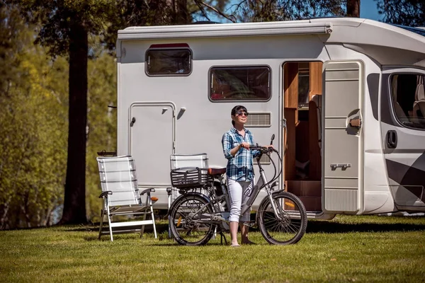 Woman on electric bike resting at the campsite VR Caravan car Va — Stock Photo, Image