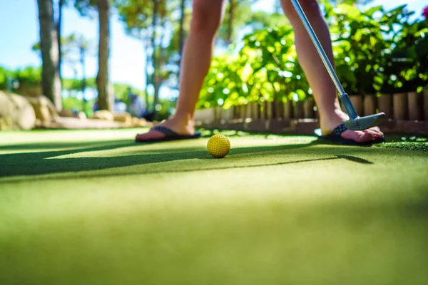 Mini Golf gele bal met een knuppel bij zonsondergang — Stockfoto