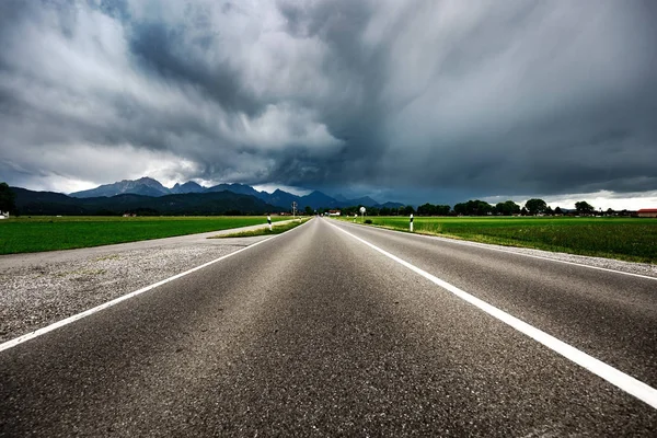 Road leading into a storm - Forggensee and Schwangau, Germany Ba — Stock Photo, Image