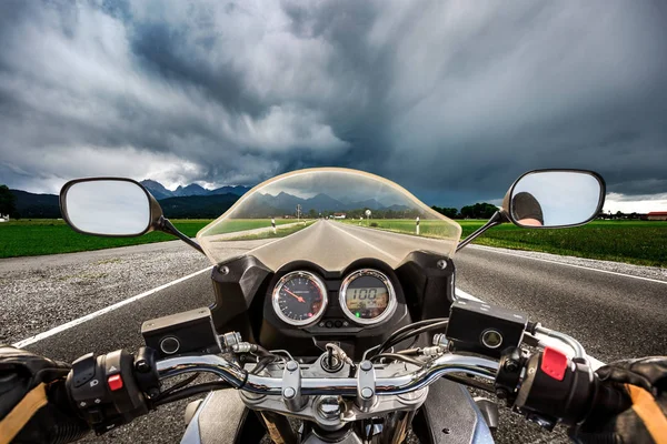 Motociclista su una moto che corre lungo la strada in un lampo stor — Foto Stock