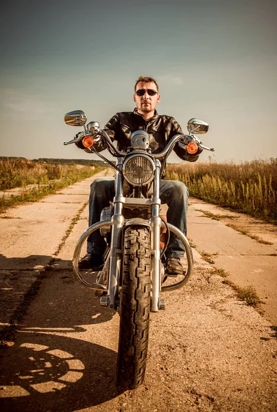 Motorcu deri ceket yolda bir motosiklet sürme — Stok fotoğraf