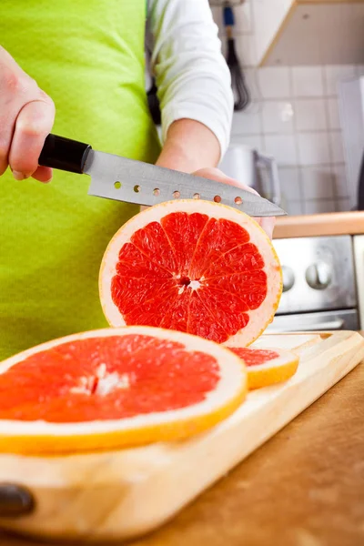 Las manos de la mujer cortando pomelo — Foto de Stock