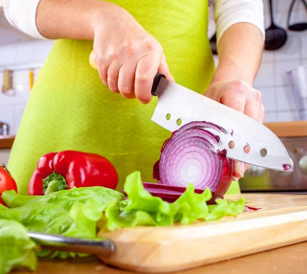 Las manos de la mujer cortando cebolla bulbo — Foto de Stock