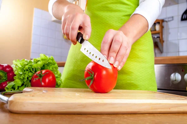 Vrouw handen snijden tomaat — Stockfoto