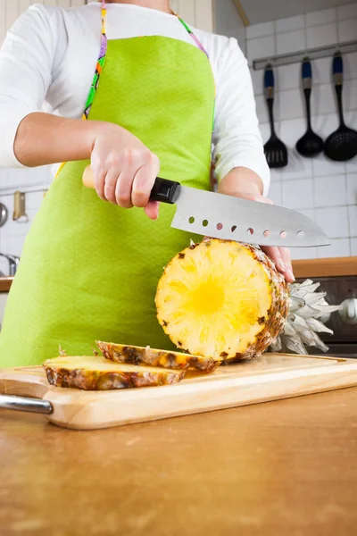 Kvinnans händer skär ananas — Stockfoto