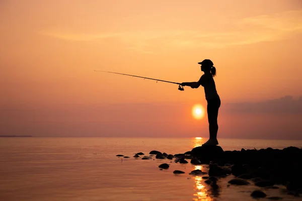 Kvinna fiske på fiskespö spinning i Norge. — Stockfoto
