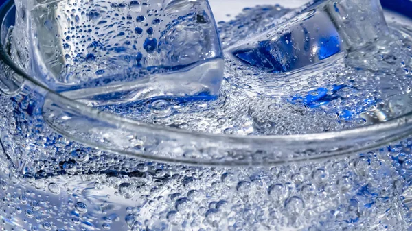 Vaso de agua con hielo sobre fondo azul oscuro —  Fotos de Stock