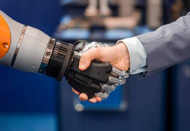 Android bir robotla el sıkışan bir iş adamının eli. Yapay zekayla insan etkileşimi kavramı.