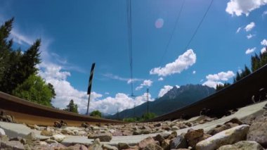 Yolcu treninin hızlı geçişi rayların altında görünüyor. Videoda ses var.