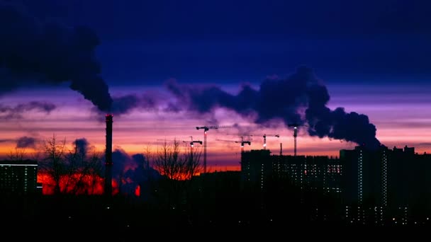 Moderne stad in de avond bij zonsondergang. Er komt rook uit de leidingen.. — Stockvideo