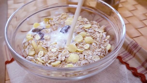 Cereales integrales muesli en un tazón para un delicioso desayuno con leche. Movimiento lento con disparo de seguimiento de rotación . — Vídeo de stock