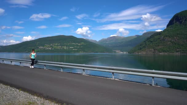 Žena běhá venku. Norský fjord. — Stock video