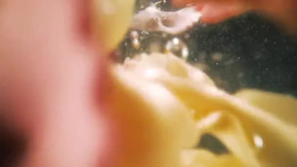スローモーションで水に落ちる色のファーフォールパスタ. — ストック動画