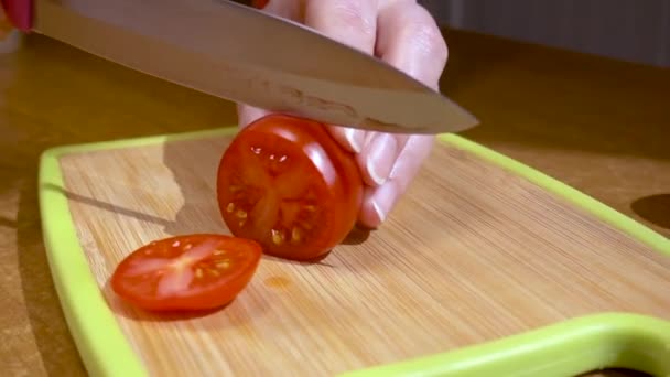 Mes snijdt tomaat op houten plank Slow motion met rotatie tracking shot. — Stockvideo