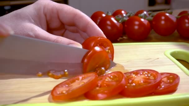 Mes snijdt tomaat op houten plank Slow motion met rotatie tracking shot. — Stockvideo