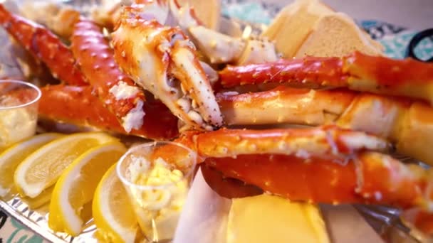 Patas de cangrejo rey rojo con rodajas de limón fresco. Delicioso menú de mariscos y restaurantes de lujo. — Vídeo de stock