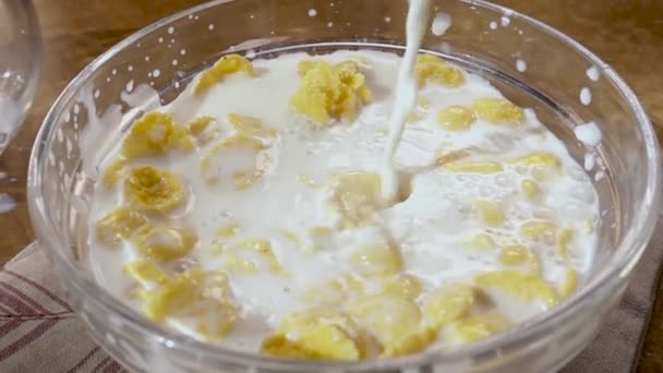 Τραγανό κίτρινο κορν φλέικς στο μπολ για το πρωί ένα νόστιμο πρωινό με γάλα. Αργή κίνηση με περιστροφή εντοπισμό shot. — Αρχείο Βίντεο
