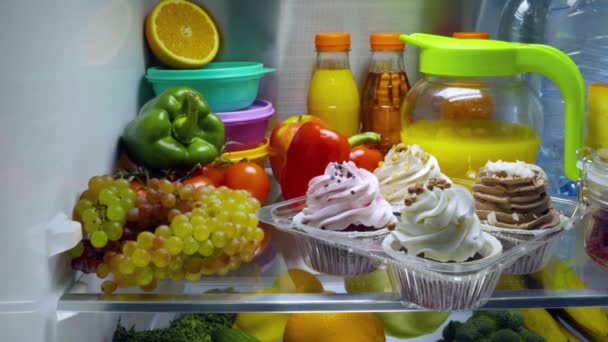 Bolos doces no refrigerador aberto. Produtos no refrigerador . — Vídeo de Stock