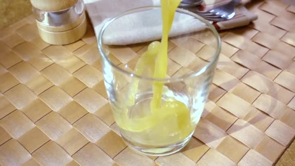 Апельсиновый сок наливается в стакан, утренний завтрак. Медленное движение с отслеживанием вращения снимка . — стоковое видео