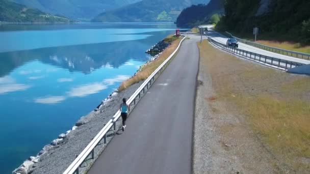 Mujer corriendo al aire libre. Fiordo noruego . — Vídeo de stock
