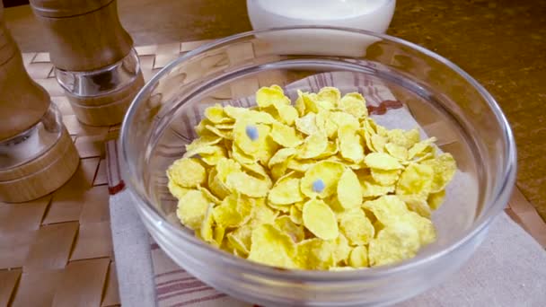 Croccanti fiocchi di mais giallo nella ciotola per la mattina una deliziosa colazione con latte. Movimento lento con inseguimento a rotazione . — Video Stock