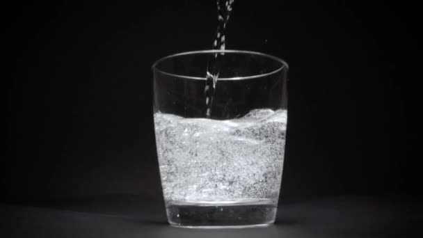 Eau minérale dans un verre transparent au ralenti 