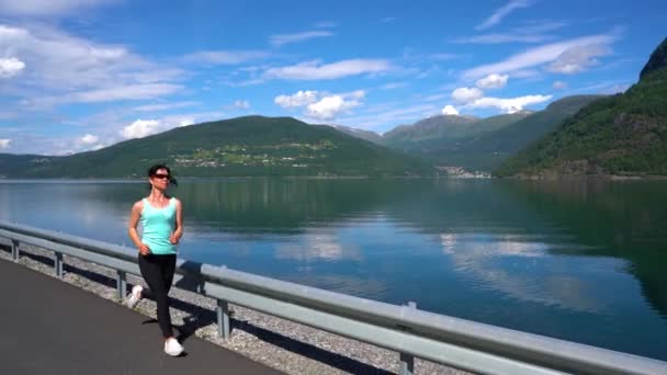 Mujer corriendo al aire libre. Fiordo noruego . — Vídeo de stock