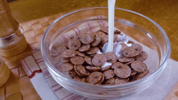 Fulgi crocanți de ciocolată într-un castron pentru un mic dejun delicios de dimineață cu lapte. Mișcare lentă cu împușcare de urmărire prin rotație . — Videoclip de stoc