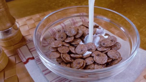 Copos de chocolate crujientes en un tazón para un delicioso desayuno con leche por la mañana. Movimiento lento con disparo de seguimiento de rotación . — Vídeos de Stock