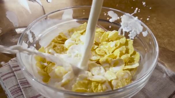 朝のボウルにクリスピーな黄色のコーンフレークミルクとおいしい朝食。回転トラッキングショット付きスローモーション. — ストック動画