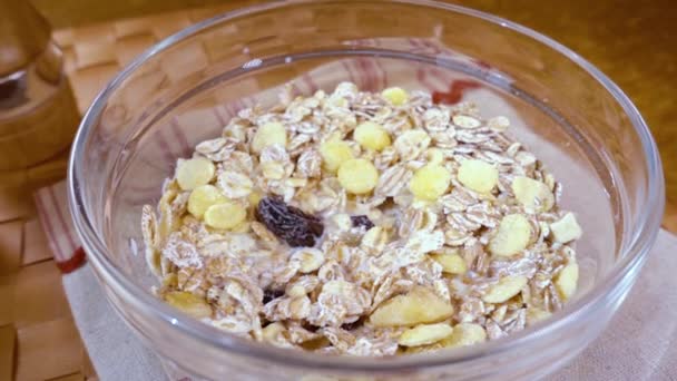 Muesli sereal gandum utuh dalam mangkuk untuk sarapan pagi yang lezat dengan susu. Gerakan lambat dengan tembakan pelacakan rotasi. — Stok Video