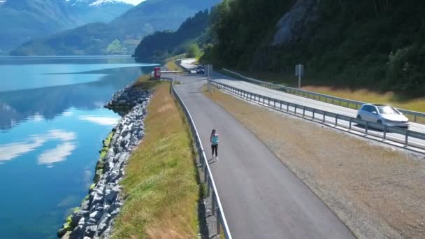 Žena běhá venku. Norský fjord. — Stock video