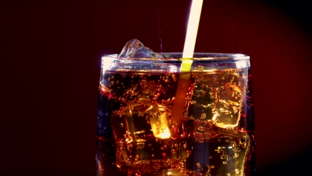 Cola e tubo de bebida com gelo e bolhas em vidro . — Vídeo de Stock