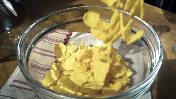 清脆的黄色玉米片倒入碗中,一上午享用美味的早餐加牛奶.旋转跟踪射击慢动作. — 图库视频影像