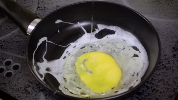 Fried egg. Raw egg on the frying pan in slow motion. — Stock Video