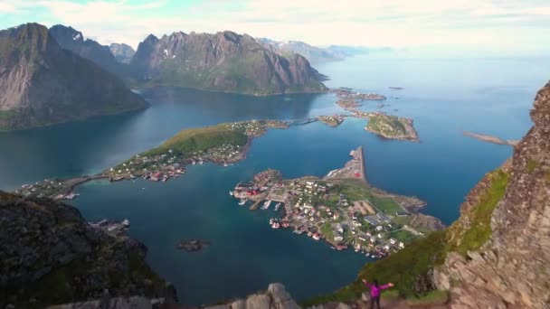 Wandelaar vrouw staat met handen omhoog het bereiken van de top. Lofoten is een plaats in de Noorse gemeente Nordland, provincie Nordland.. — Stockvideo